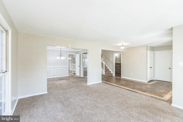 carpeted spare room featuring a notable chandelier