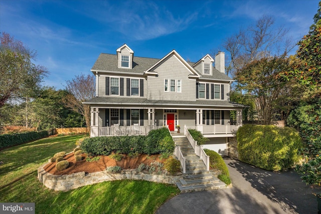 view of front of home featuring a front yard, a garage, and a porch