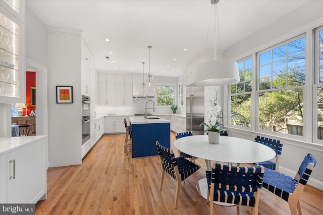 dining area featuring sink, light hardwood / wood-style floors, and plenty of natural light