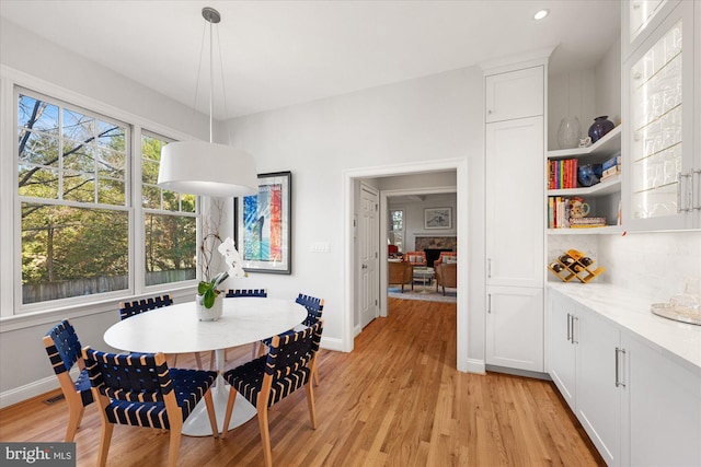 dining room featuring a fireplace and light hardwood / wood-style flooring