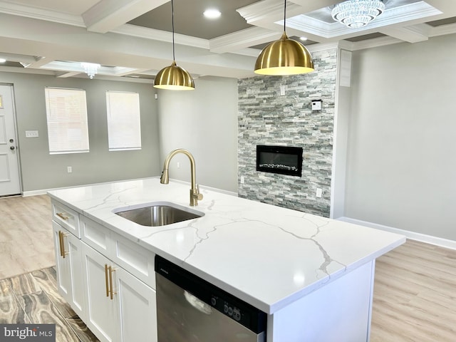 kitchen featuring pendant lighting, dishwasher, white cabinets, sink, and light stone countertops