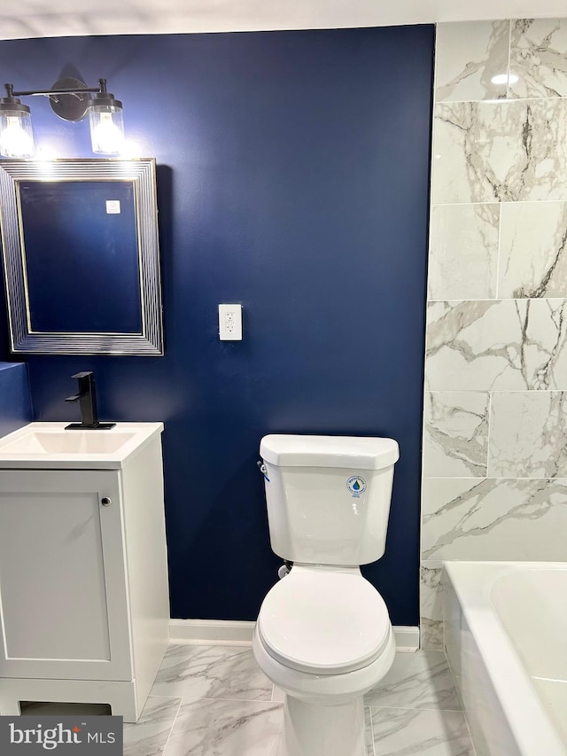 bathroom featuring vanity, toilet, and a washtub