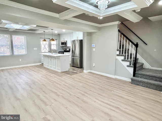 kitchen with white cabinets, light hardwood / wood-style flooring, decorative light fixtures, a kitchen island, and stainless steel appliances