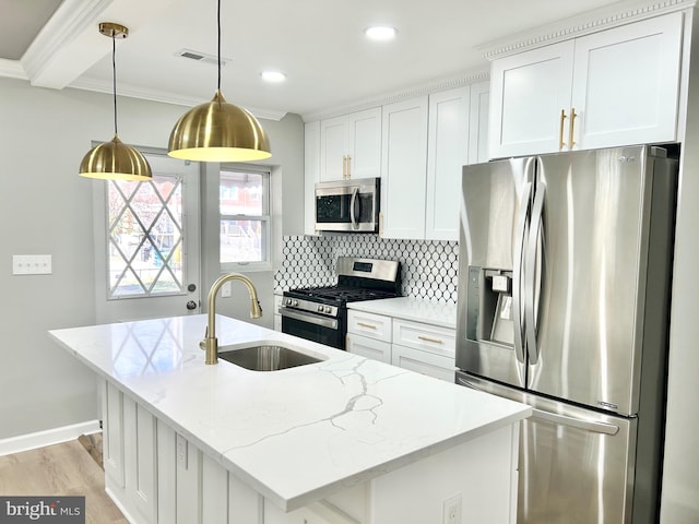 kitchen featuring hanging light fixtures, stainless steel appliances, light stone counters, and white cabinetry