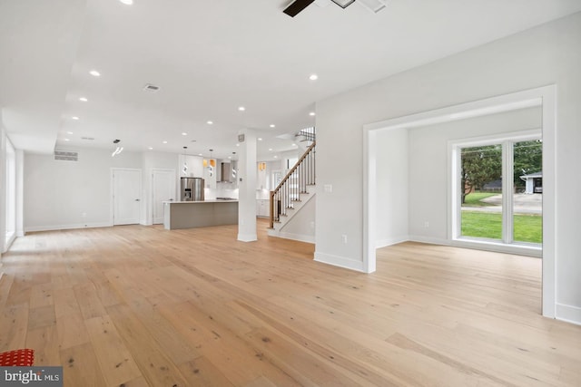 unfurnished living room featuring light hardwood / wood-style floors and ceiling fan