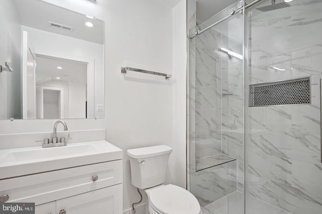 bathroom featuring vanity, toilet, and a shower with shower door