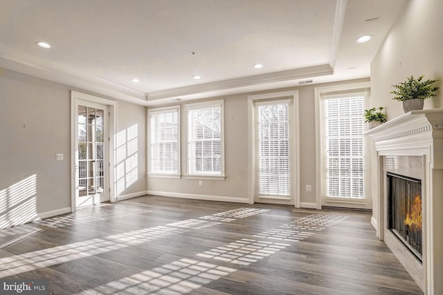 unfurnished living room with a healthy amount of sunlight, dark wood-type flooring, and a high end fireplace