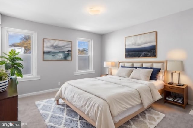 bedroom featuring light carpet and multiple windows