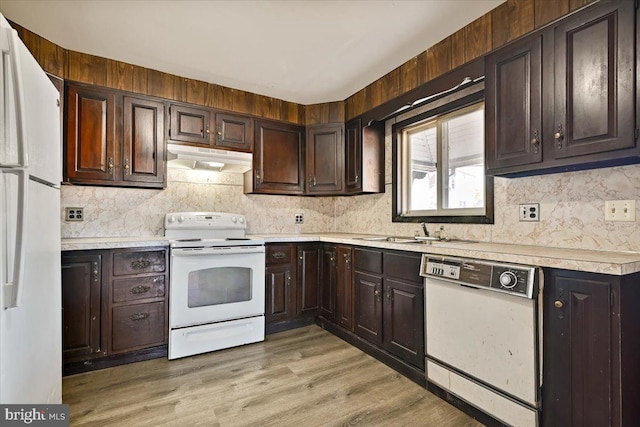 kitchen with sink, backsplash, white appliances, dark brown cabinets, and light hardwood / wood-style flooring