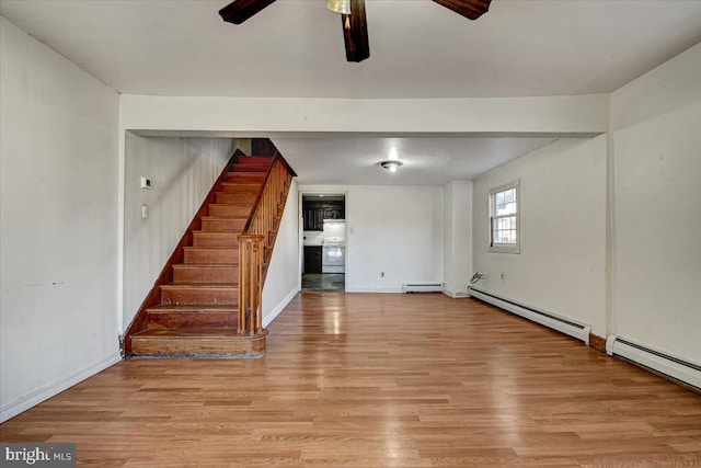 interior space with light hardwood / wood-style flooring, ceiling fan, and a baseboard heating unit