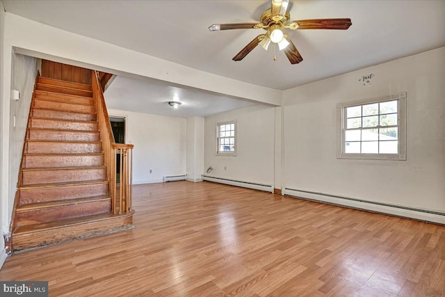 spare room featuring a wealth of natural light, a baseboard radiator, and light hardwood / wood-style flooring