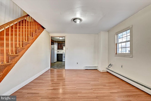 spare room featuring a baseboard radiator and light wood-type flooring