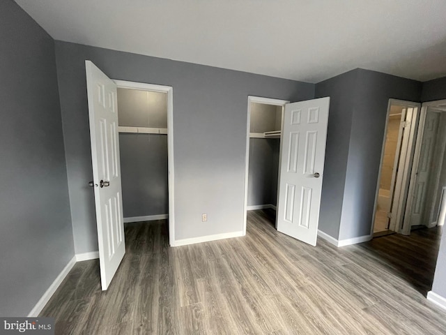 unfurnished bedroom featuring hardwood / wood-style floors and a spacious closet