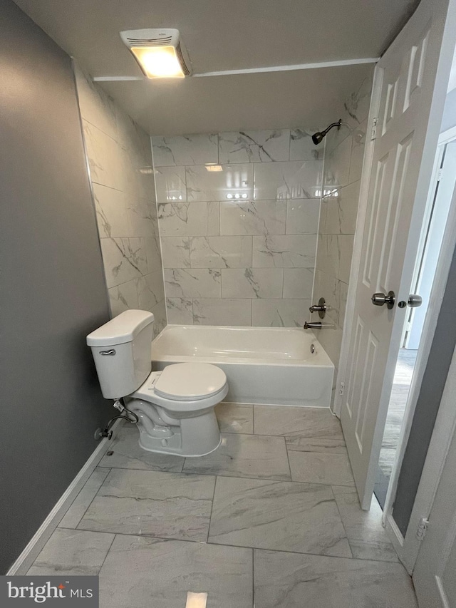 bathroom featuring tiled shower / bath and toilet