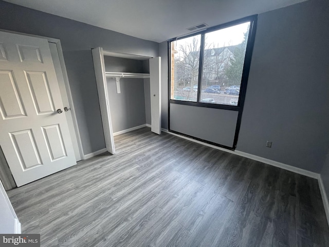 unfurnished bedroom with wood-type flooring and a closet