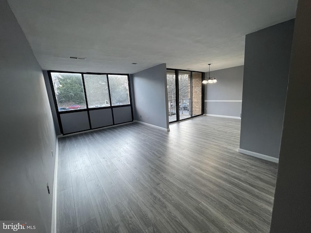 unfurnished room featuring a chandelier and wood-type flooring