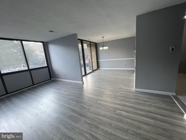 spare room featuring a chandelier and dark hardwood / wood-style floors