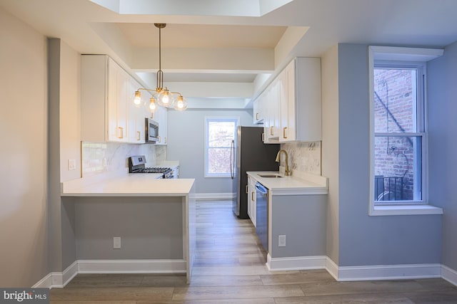 kitchen featuring decorative backsplash, white cabinets, and appliances with stainless steel finishes