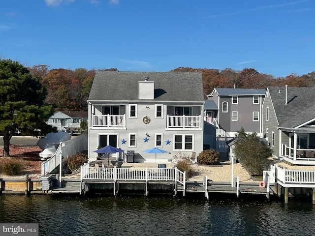 rear view of property featuring a balcony and a deck with water view