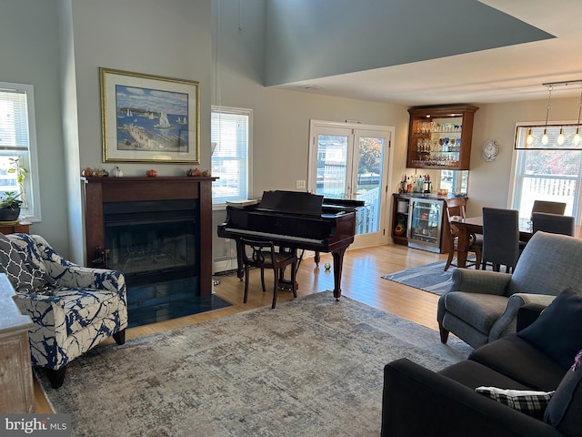 interior space featuring bar area, beverage cooler, a wealth of natural light, and light hardwood / wood-style floors