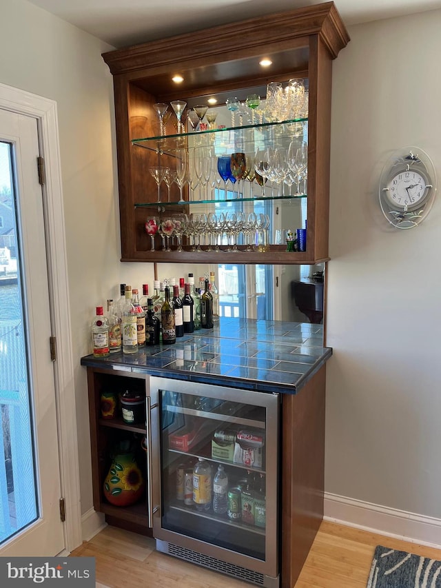 bar featuring a wealth of natural light and light hardwood / wood-style flooring