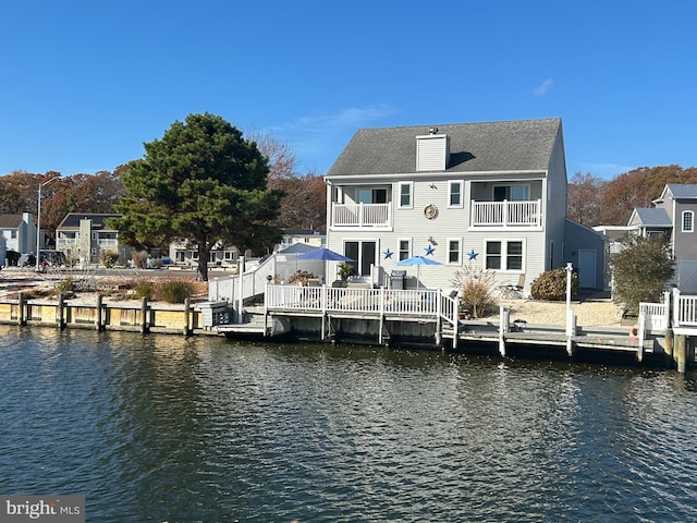 back of property featuring a water view and a balcony