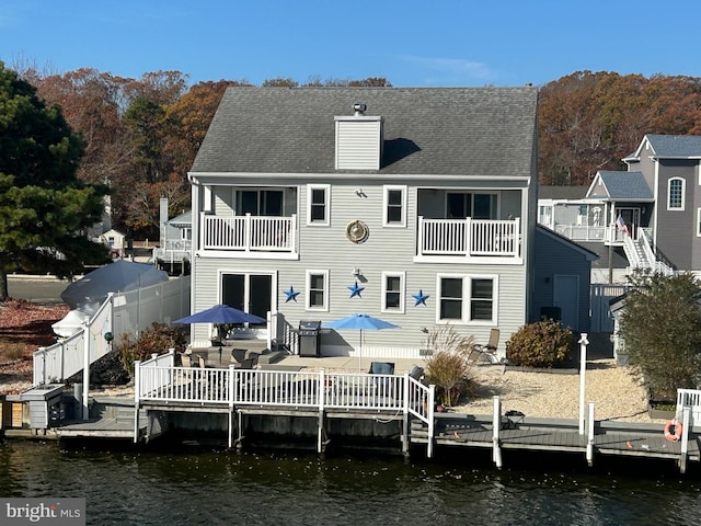 rear view of house featuring a balcony and a deck with water view