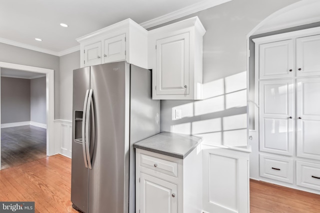 kitchen with stainless steel refrigerator with ice dispenser, light hardwood / wood-style floors, white cabinetry, and crown molding