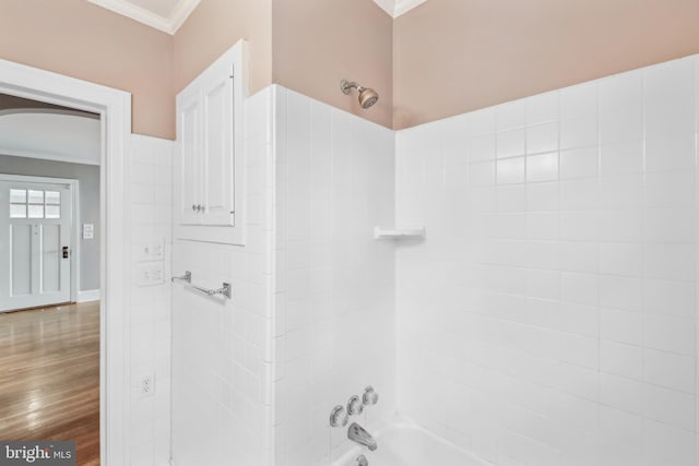 bathroom with crown molding, hardwood / wood-style floors, and shower / bathing tub combination