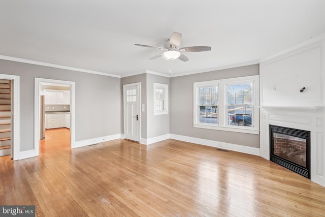 unfurnished living room featuring light hardwood / wood-style floors, ceiling fan, and crown molding