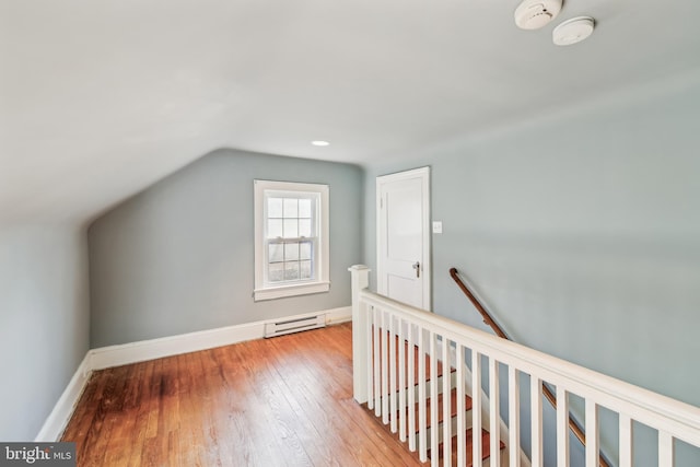 additional living space featuring light hardwood / wood-style flooring, a baseboard radiator, and lofted ceiling