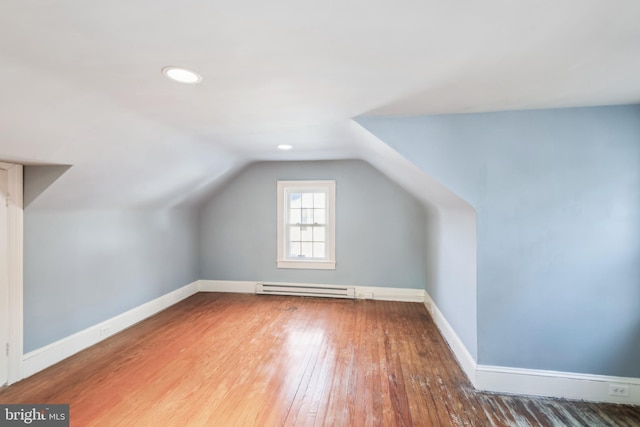 bonus room featuring hardwood / wood-style floors, a baseboard radiator, and vaulted ceiling