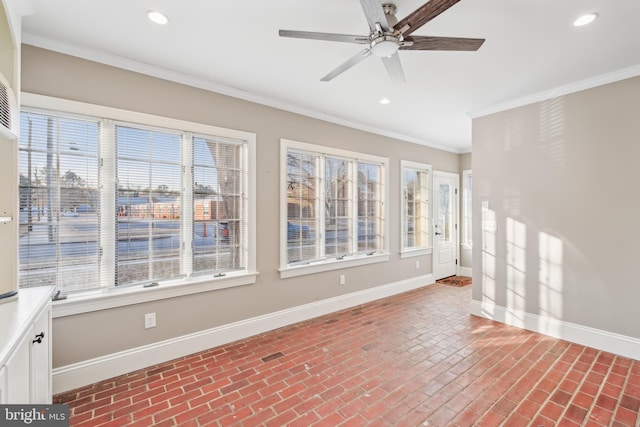 unfurnished sunroom featuring ceiling fan and a healthy amount of sunlight