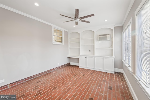 spare room featuring built in shelves, ceiling fan, crown molding, and a wall mounted AC