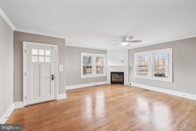 unfurnished living room featuring ceiling fan, crown molding, and light hardwood / wood-style floors