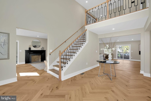 staircase with parquet flooring and a high ceiling