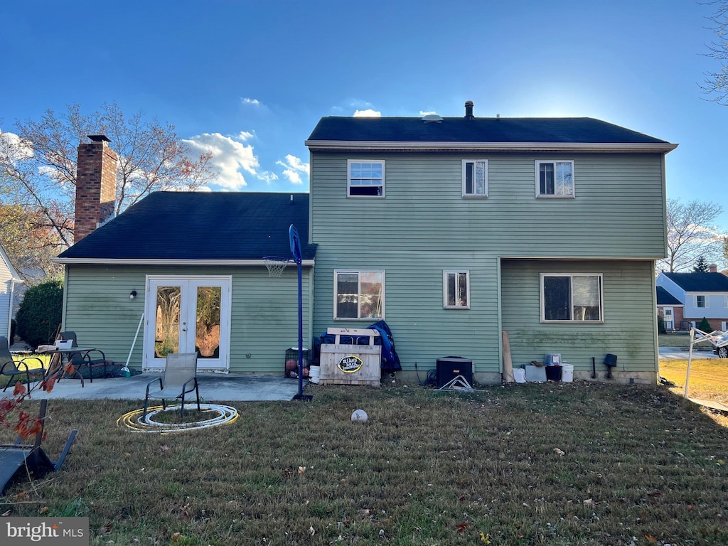 rear view of property featuring a patio area, a lawn, and french doors