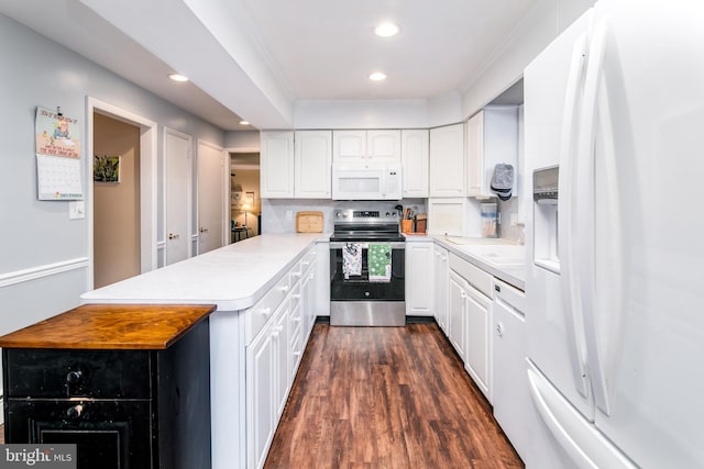 kitchen featuring white cabinetry, dark hardwood / wood-style floors, crown molding, white appliances, and decorative backsplash