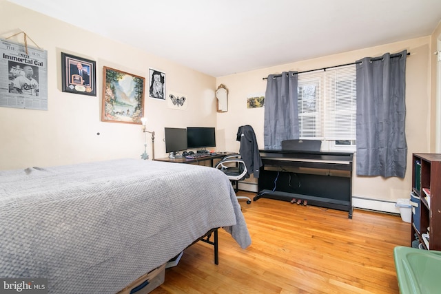 bedroom featuring wood-type flooring and a baseboard heating unit