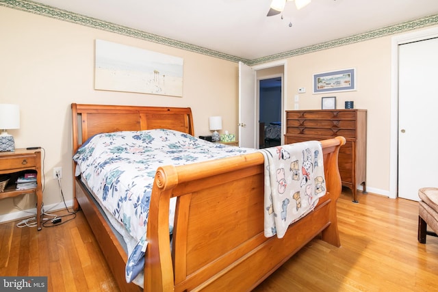 bedroom with ceiling fan, a closet, and hardwood / wood-style flooring