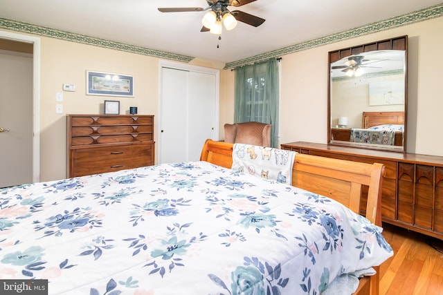 bedroom with a closet, light hardwood / wood-style floors, and ceiling fan