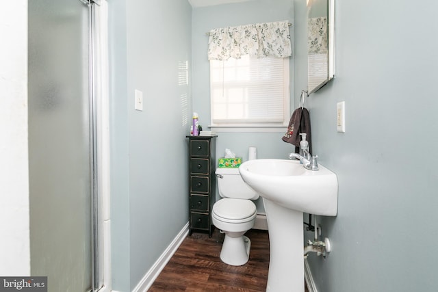 bathroom featuring wood-type flooring, an enclosed shower, and toilet