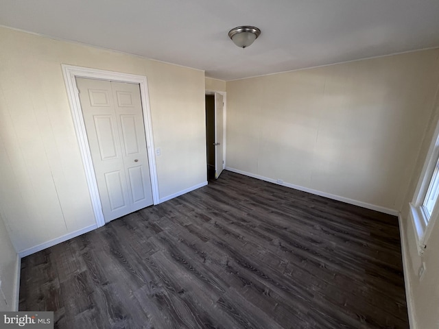 unfurnished bedroom with a closet and dark hardwood / wood-style floors