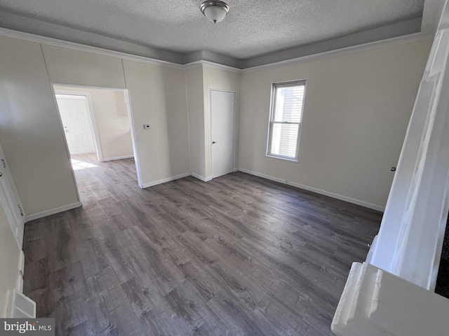 unfurnished bedroom with a textured ceiling, dark hardwood / wood-style floors, crown molding, and a closet