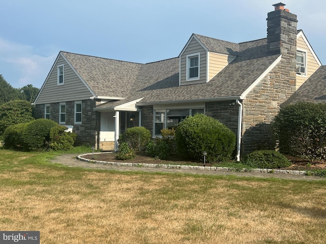 cape cod home featuring a front yard