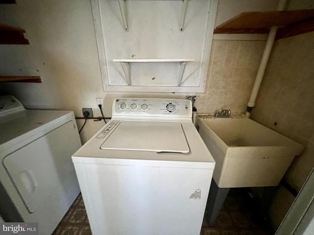 clothes washing area with washer and dryer and sink