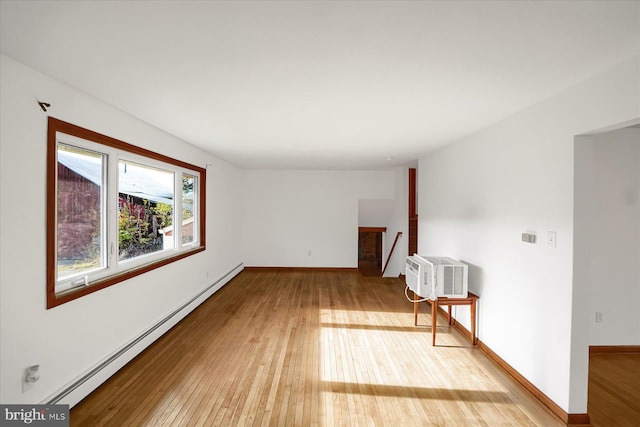 unfurnished room featuring wood-type flooring, a baseboard heating unit, and a wall mounted AC