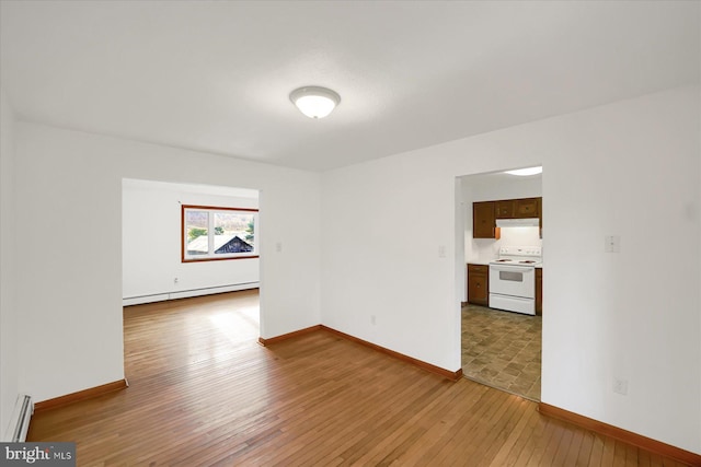 spare room featuring hardwood / wood-style floors and a baseboard radiator