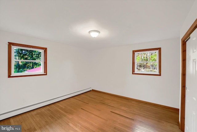 3315 E College Ave, Bellefonte, PA 16823 - unfurnished bedroom featuring a baseboard heating unit, light wood-style flooring, baseboards, and a closet