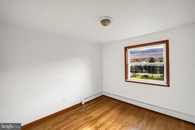 3315 E College Ave, Bellefonte, PA 16823 - empty room featuring wood finished floors, a baseboard heating unit, and baseboards
